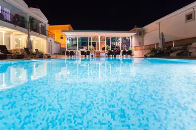 a large blue swimming pool at night at Spa Resort Luxury Apartments in Budva