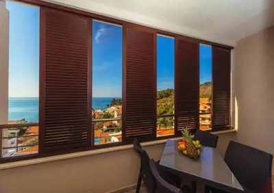 a dining room with a table and a view of the ocean at Engora 5 in Petrovac na Moru