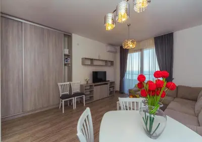 a living room with a table with red flowers on it at Engora 5 in Petrovac na Moru