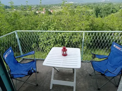 a white table and two chairs on a balcony at Country stone house Kovacevic in Danilovgrad