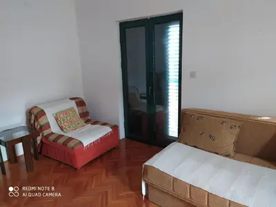 a living room with a couch and a chair at Apartman Potkošljun in Budva