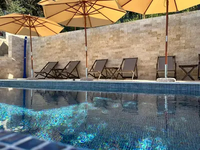 a group of chairs and umbrellas next to a swimming pool at CASA BIANCA & Spa 2 in Ulcinj