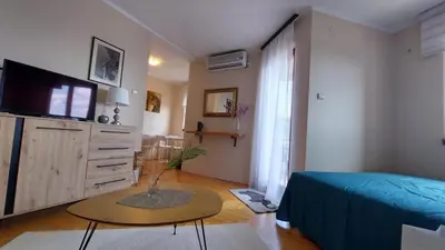 a bedroom with a bed and a table and a tv at Dream Studio in Budva
