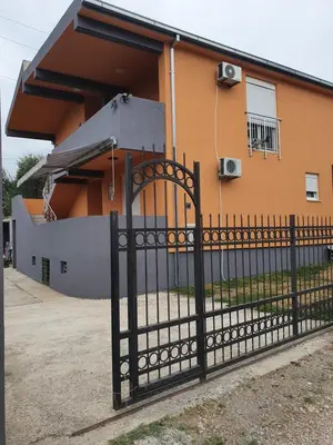 a black fence in front of a house at Apartmen Kuca za odmor i familiju in Bar