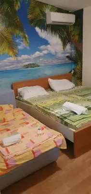 two beds in a room with a painting on the wall at Apartmen Kuca za odmor i familiju in Bar