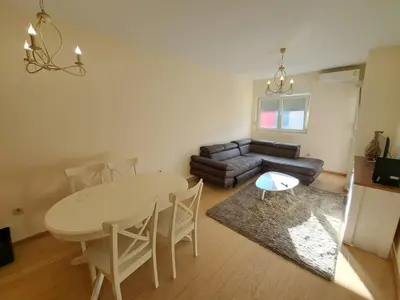 a living room with a table and a couch at Delta apartment City kvart in Podgorica