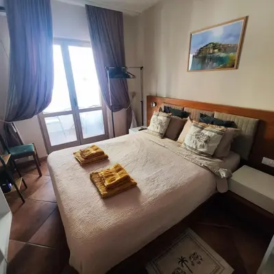 a bedroom with a large bed with two trays on it at Studio 75 meters to the sea in Rafailovici