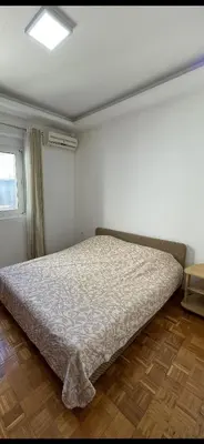 a bedroom with a bed in a room with a window at Apartmani centar ulcinj in Ulcinj